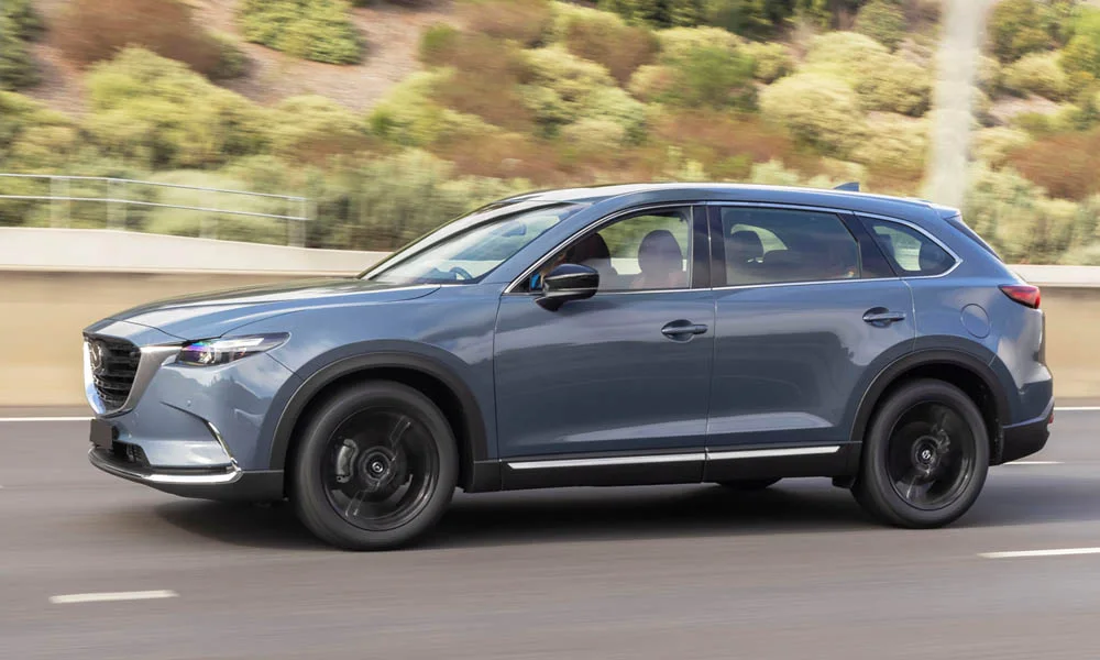 Фото Mazda CX-9 — вид сбоку, фото 3. Профиль в синем цвете: соотношение колёсной базы и свесов. Длинная база — простор второго ряда; короткие свесы упрощают парковку Mazda CX-9 — вид сбоку, фото 3