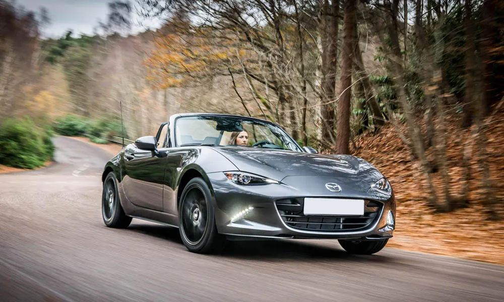 Фото Mazda MX-5 — вид спереди, фото 5. Серебристый кузов, строгая симметрия оптики — базовый ракурс знакомства с дизайном Mazda MX-5 — вид спереди, фото 5
