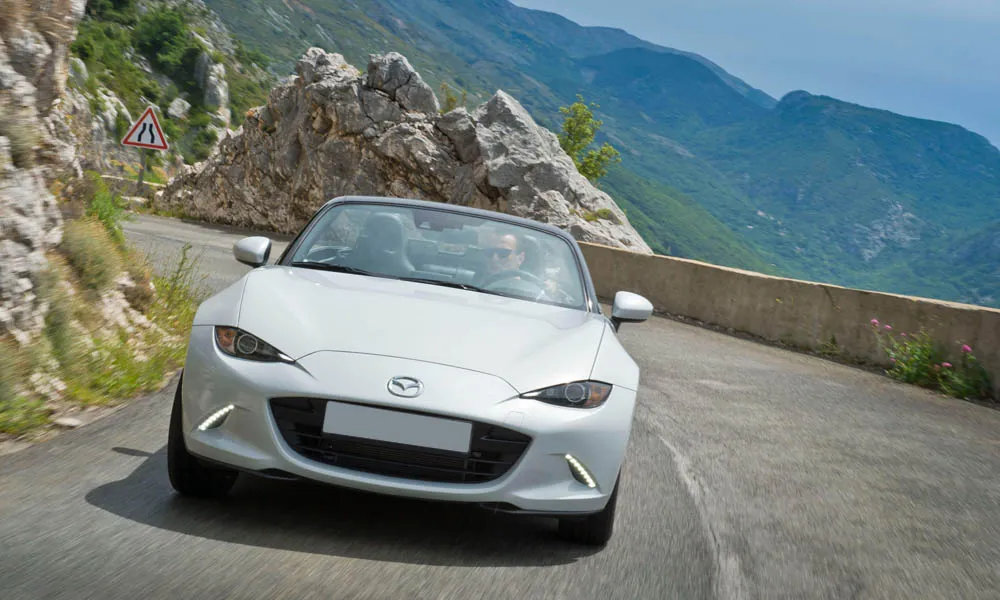 Фото Mazda MX-5 — вид спереди, фото 8. Передок в серебристом исполнении — крупная светотехника и выразительный бампер Mazda MX-5 — вид спереди, фото 8