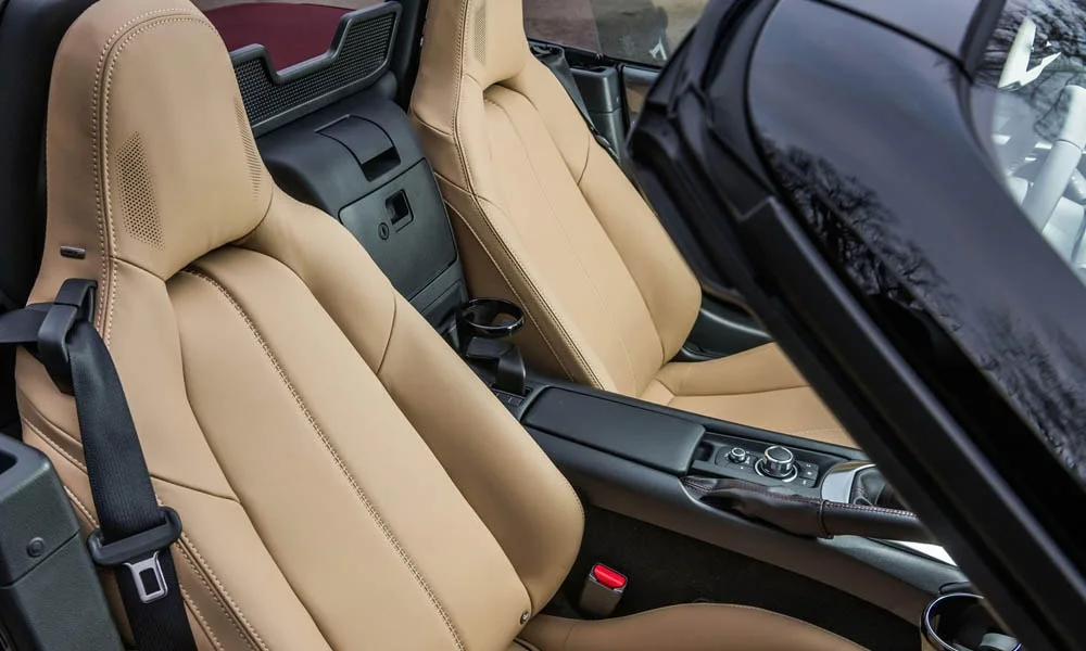 Фото Mazda MX-5 — интерьер. Общий план салона: архитектура панели, консоль и кресла. Светлая гамма зрительно расширяет салон, тёмная — практичнее в уходе Mazda MX-5 — интерьер