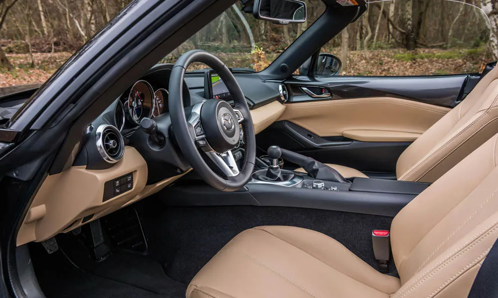 Фото Mazda MX-5 — интерьер, фото 3. Общий план салона: архитектура панели, консоль и кресла. Уровень отделки читается по стыкам панелей и мягким поверхностям в зонах касания Mazda MX-5 — интерьер, фото 3