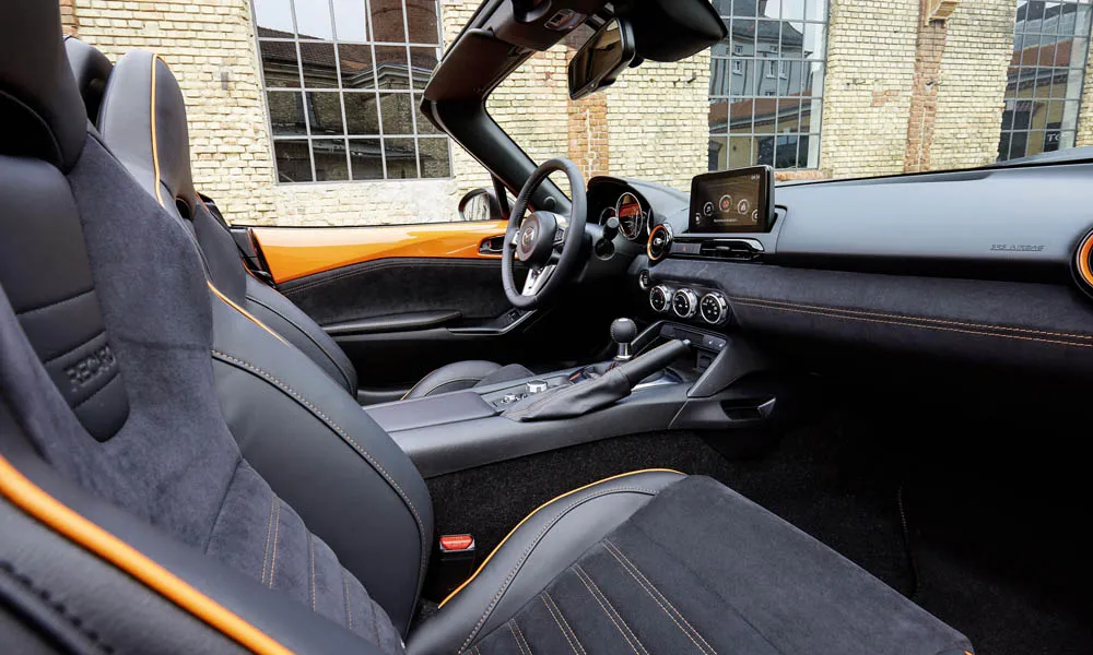 Фото Mazda MX-5 — интерьер, фото 5. Общий план салона: архитектура панели, консоль и кресла. Уровень отделки читается по стыкам панелей и мягким поверхностям в зонах касания Mazda MX-5 — интерьер, фото 5