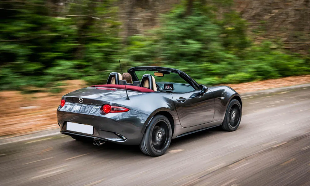 Фото Mazda MX-5 — вид сзади, фото 5. Корма в сером цвете: графика фонарей и пластика пятой двери. Светодиодная полоса или раздельные секции — задняя оптика стала главным украшением кормы Mazda MX-5 — вид сзади, фото 5