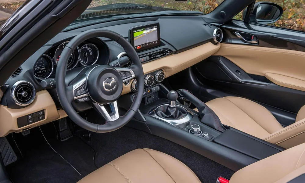 Фото Mazda MX-5 — руль. Обшивка обода и компоновка спиц крупным планом. Правильная посадка: руки на «9 и 3», приборы читаются поверх обода Mazda MX-5 — руль