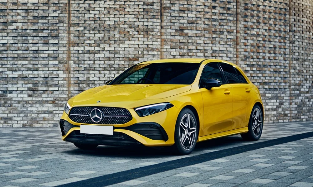 Фото Mercedes-Benz A-Class (2024) — вид спереди. Передок в жёлтом исполнении — крупная светотехника и выразительный бампер Mercedes-Benz A-Class (2024) — вид спереди