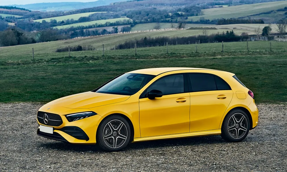 Фото Mercedes-Benz A-Class (2024) — вид спереди, фото 2. Передок в жёлтом исполнении — крупная светотехника и выразительный бампер. Дневные ходовые огни включаются автоматически с запуском Mercedes-Benz A-Class (2024) — вид спереди, фото 2