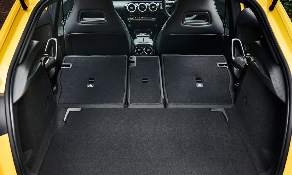 Фото Mercedes-Benz A-Class (2024) — багажник, фото 2. Форма проёма, ровный пол и организация пространства. Электропривод двери с датчиком под бампером — руки заняты, багажник открыт Mercedes-Benz A-Class (2024) — багажник, фото 2