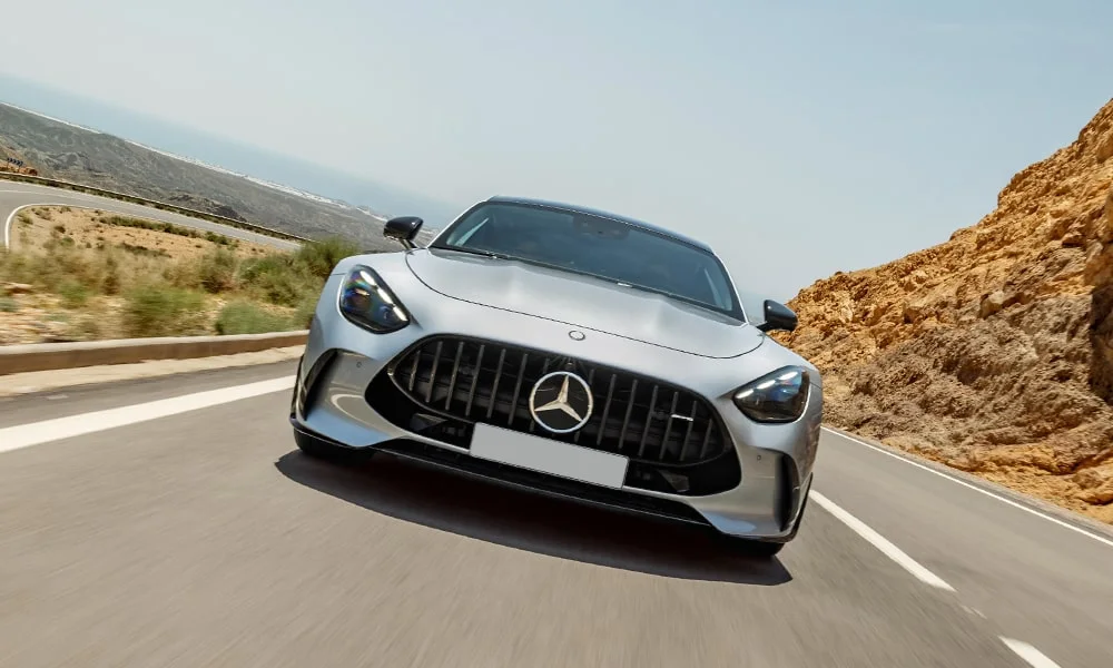 Фото Mercedes-Benz AMG GT (2024) — вид спереди, фото 9. Передок в серебристом исполнении — крупная светотехника и выразительный бампер. Дневные ходовые огни включаются автоматически с запуском Mercedes-Benz AMG GT (2024) — вид спереди, фото 9