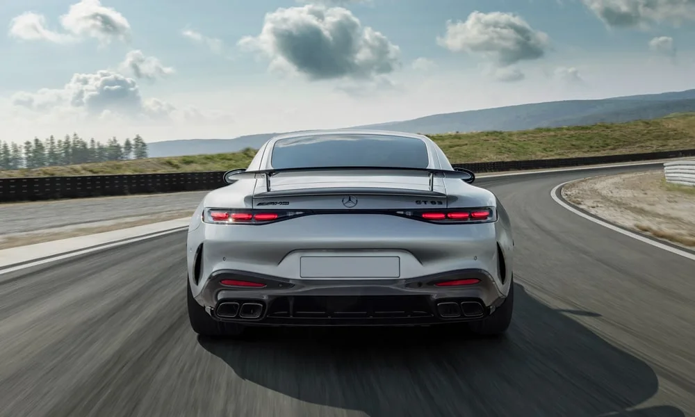 Фото Mercedes-Benz AMG GT (2024) — вид сзади, фото 5. Серый кузов сзади — фонари и бампер определяют ночной образ модели. Насадки выхлопа или их имитация внизу бампера различают версии Mercedes-Benz AMG GT (2024) — вид сзади, фото 5