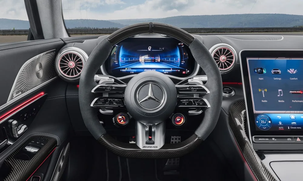 Фото Mercedes-Benz AMG GT (2024) — руль. Обшивка обода и компоновка спиц крупным планом. Клавиши на спицах управляют медиа, круизом и ассистентами — руки остаются на руле Mercedes-Benz AMG GT (2024) — руль