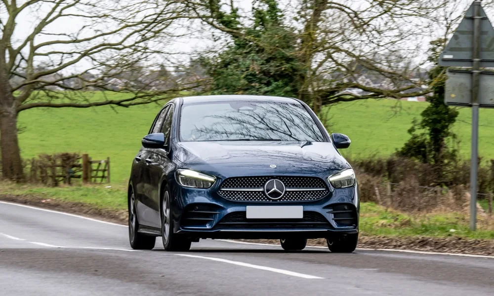 Фото Mercedes-Benz B-Class (2024) — вид спереди, фото 2. Передок в синем исполнении — крупная светотехника и выразительный бампер Mercedes-Benz B-Class (2024) — вид спереди, фото 2