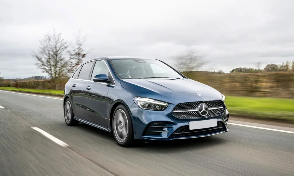 Фото Mercedes-Benz B-Class (2024) — вид спереди, фото 4. Передок в синем исполнении — крупная светотехника и выразительный бампер. Дневные ходовые огни включаются автоматически с запуском Mercedes-Benz B-Class (2024) — вид спереди, фото 4