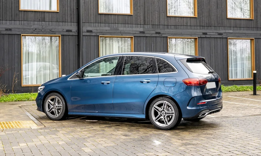 Фото Mercedes-Benz B-Class (2024) — вид сзади. Корма в синем цвете: графика фонарей и пластика пятой двери Mercedes-Benz B-Class (2024) — вид сзади
