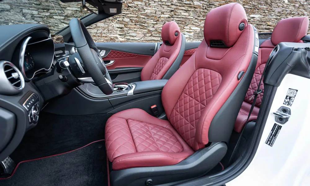 Фото Mercedes-Benz C-Class — интерьер. Салон в красно-чёрной отделке: архитектура передней панели, консоль и кресла. Уровень отделки читается по стыкам панелей и мягким поверхностям в зонах касания Mercedes-Benz C-Class — интерьер