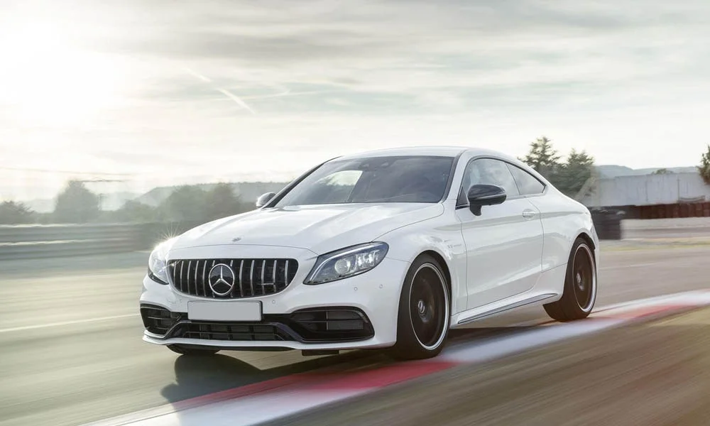 Фото Mercedes-Benz C-Class — вид спереди, фото 29. Белый кузов, строгая симметрия оптики — базовый ракурс знакомства с дизайном. Рисунок ходовых огней — подпись модели, по нему её узнают в потоке Mercedes-Benz C-Class — вид спереди, фото 29