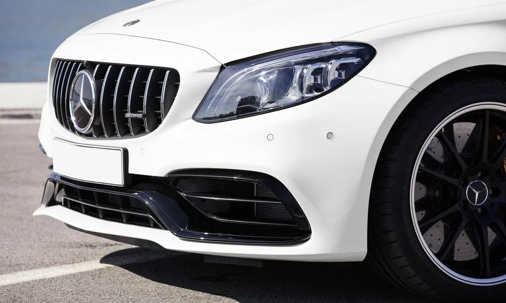 Фото Mercedes-Benz C-Class — вид спереди, фото 31. Передок в белом исполнении — крупная светотехника и выразительный бампер. Рисунок ходовых огней — подпись модели, по нему её узнают в потоке Mercedes-Benz C-Class — вид спереди, фото 31