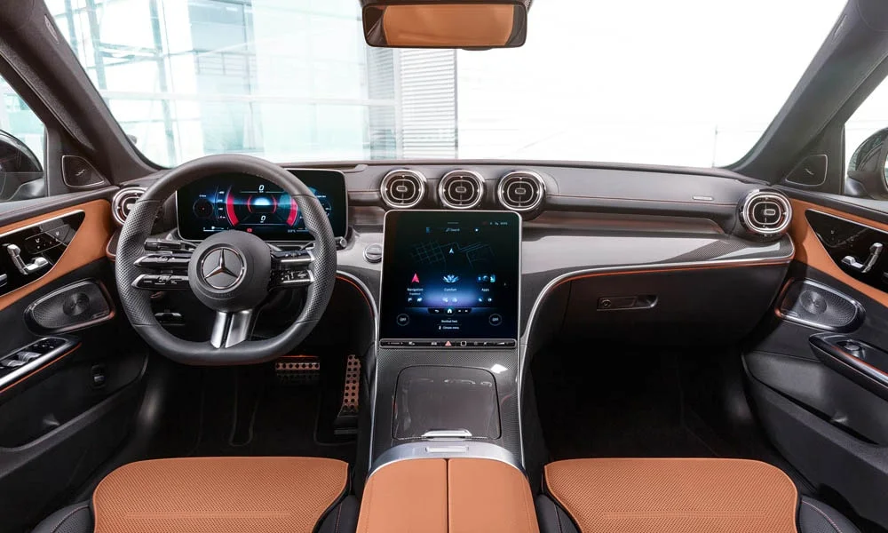 Фото Mercedes-Benz C-Class — передняя панель. Панель в коричневой отделке — видна компоновка экранов и органов управления. Мягкие материалы верхнего яруса и вставки задают уровень интерьера Mercedes-Benz C-Class — передняя панель