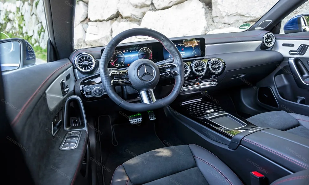 Фото Mercedes-Benz CLA (2024) — передняя панель. Панель в тёмной отделке — видна компоновка экранов и органов управления. Мягкие материалы верхнего яруса и вставки задают уровень интерьера Mercedes-Benz CLA (2024) — передняя панель
