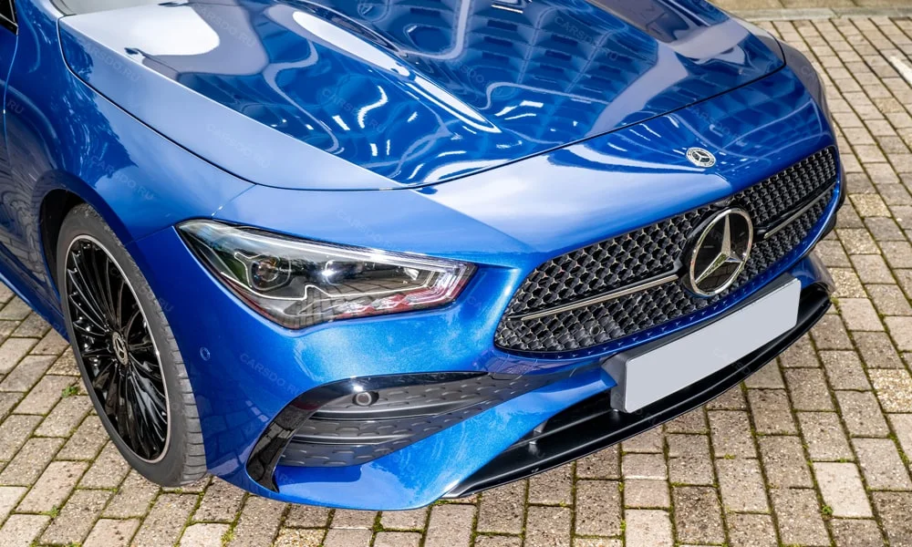 Фото Mercedes-Benz CLA (2024) — вид спереди, фото 9. Передок в синем исполнении — крупная светотехника и выразительный бампер Mercedes-Benz CLA (2024) — вид спереди, фото 9