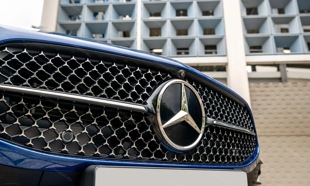 Фото Mercedes-Benz CLA (2024) — решётка радиатора. Фирменный рисунок облицовки — визитная карточка марки. Активные жалюзи за решёткой закрываются на трассе ради аэродинамики — есть у ряда моделей Mercedes-Benz CLA (2024) — решётка радиатора