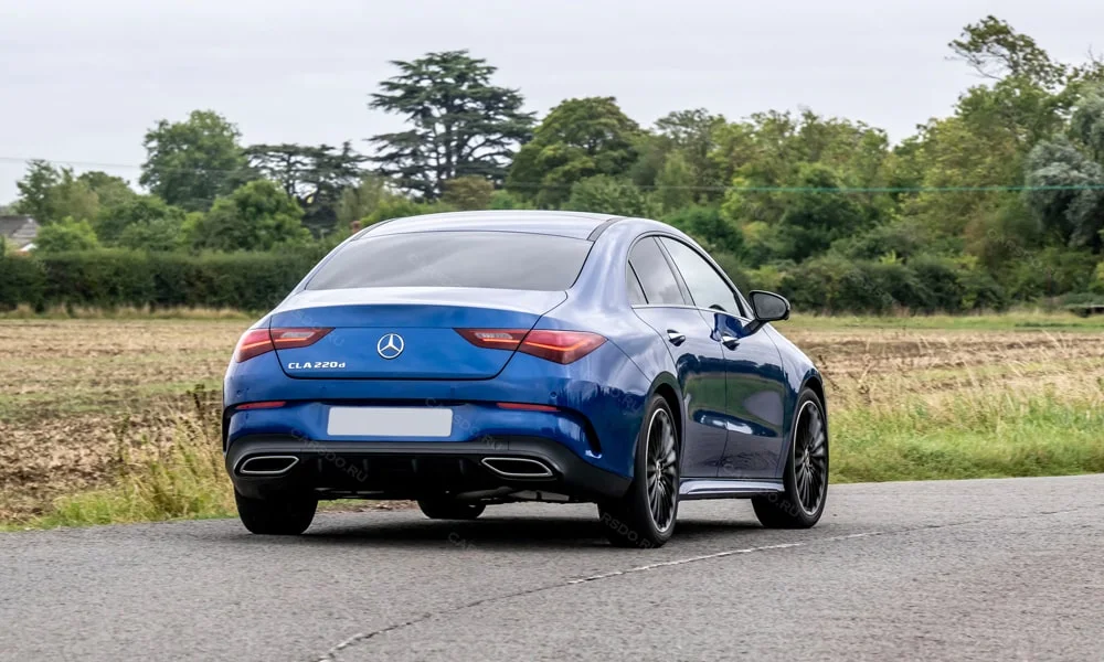 Фото Mercedes-Benz CLA (2024) — вид сзади, фото 8. Линия крыши, стойки и задняя дверь в синем исполнении. Насадки выхлопа или их имитация внизу бампера различают версии Mercedes-Benz CLA (2024) — вид сзади, фото 8