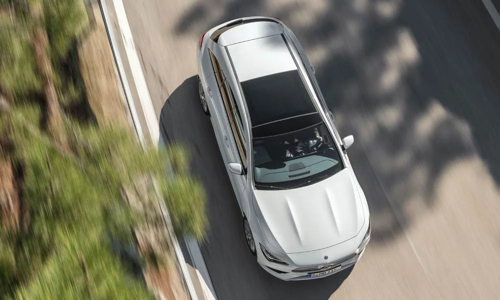 Фото Mercedes-Benz CLA — крыша. Крыша сверху: остекление, рейлинги и антенна-плавник. Панорамное стекло зрительно увеличивает салон; шторка спасает в жару Mercedes-Benz CLA — крыша