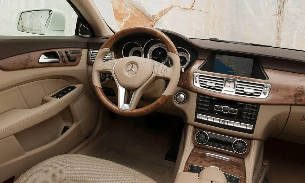 Фото Mercedes-Benz CLS — передняя панель. Панель в светлой бежевой отделке — видна компоновка экранов и органов управления Mercedes-Benz CLS — передняя панель