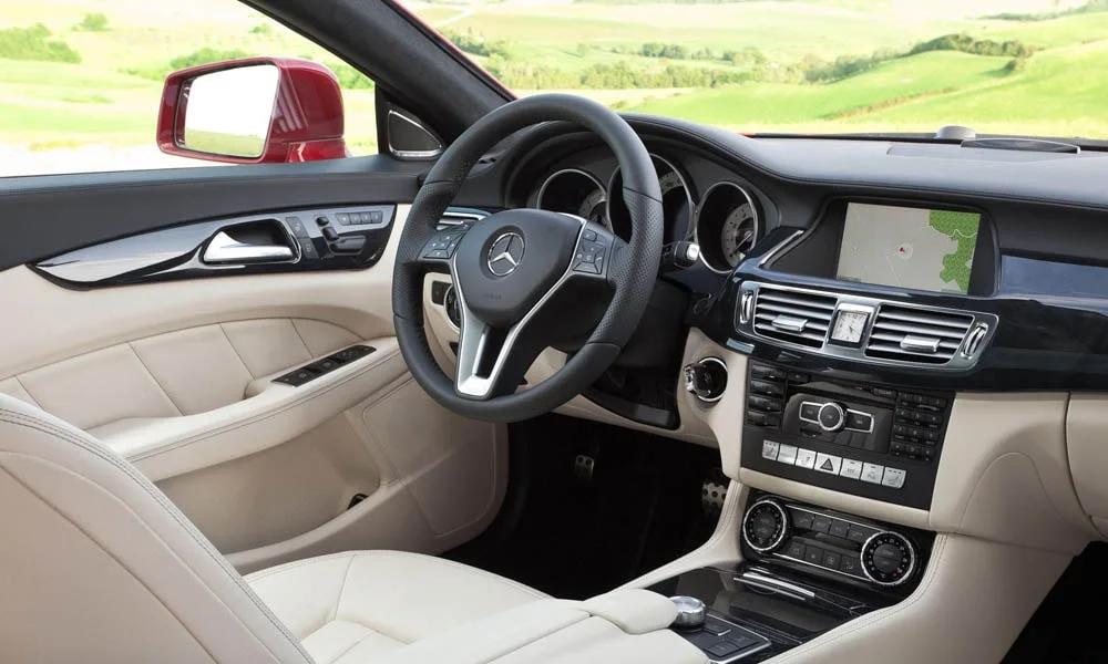 Фото Mercedes-Benz CLS — передняя панель, фото 3. Панель в светлой бежевой отделке — видна компоновка экранов и органов управления. Мягкие материалы верхнего яруса и вставки задают уровень интерьера Mercedes-Benz CLS — передняя панель, фото 3