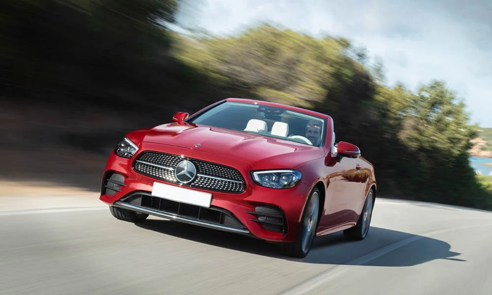 Фото Mercedes-Benz E-Class — вид спереди, фото 21. Передок в красном исполнении — крупная светотехника и выразительный бампер. Рисунок ходовых огней — подпись модели, по нему её узнают в потоке Mercedes-Benz E-Class — вид спереди, фото 21