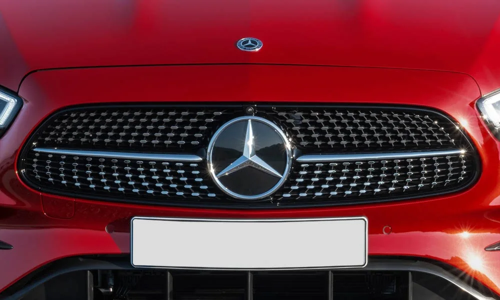 Фото Mercedes-Benz E-Class — решётка радиатора. Фирменный рисунок облицовки — визитная карточка марки. Активные жалюзи за решёткой закрываются на трассе ради аэродинамики — есть у ряда моделей Mercedes-Benz E-Class — решётка радиатора