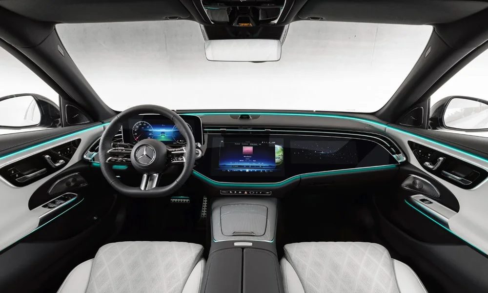 Фото Mercedes-Benz E-Class (2024) — передняя панель. Архитектура передней панели: ярусы, вставки и консоль в светло-серой гамме. Минимум физических кнопок — ставка на экранное управление Mercedes-Benz E-Class (2024) — передняя панель