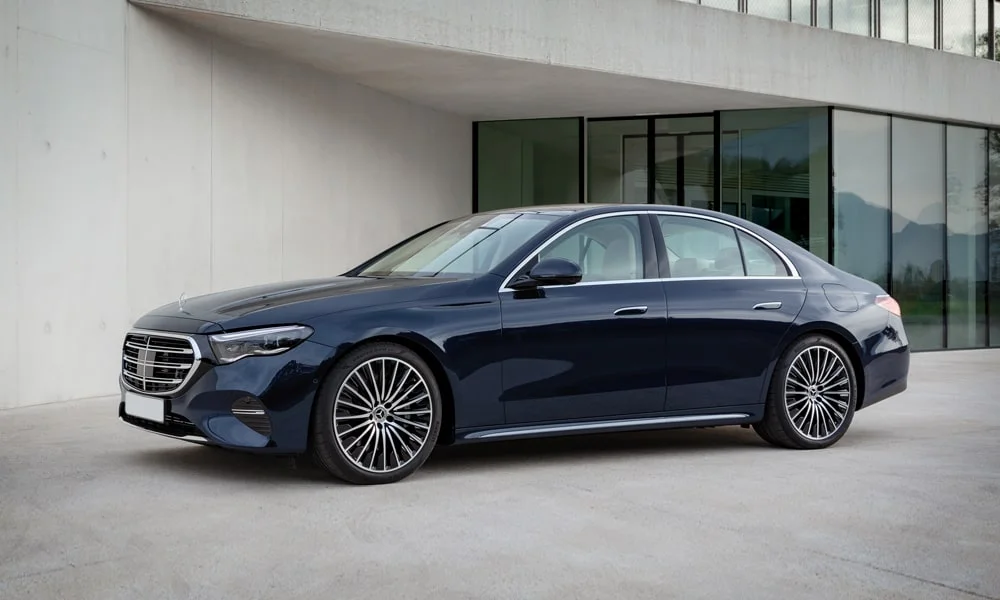 Фото Mercedes-Benz E-Class (2024) — вид спереди, фото 3. Кузов в синем цвете: рисунок оптики и решётки задаёт узнаваемое «лицо» модели Mercedes-Benz E-Class (2024) — вид спереди, фото 3