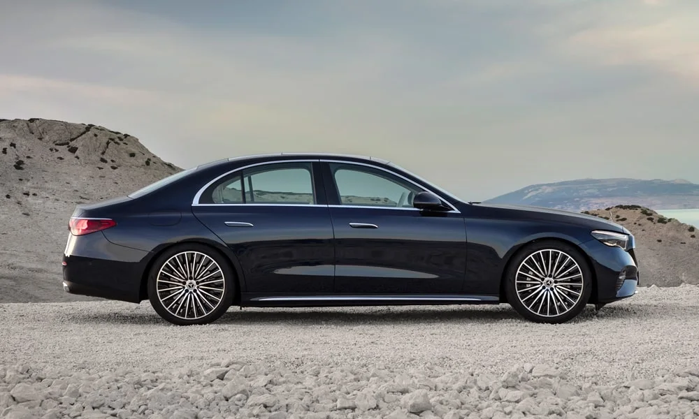 Фото Mercedes-Benz E-Class (2024) — вид сбоку. Профиль кузова: колёсная база, свесы и линия остекления. Хромированные или чёрные молдинги окон отличают комплектации Mercedes-Benz E-Class (2024) — вид сбоку