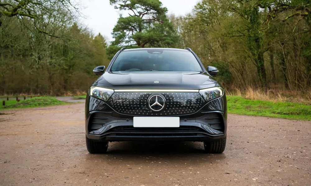 Фото Mercedes-Benz EQA (2024) — вид спереди, фото 3. Передок в чёрном исполнении — крупная светотехника и выразительный бампер. Рисунок ходовых огней — подпись модели, по нему её узнают в потоке Mercedes-Benz EQA (2024) — вид спереди, фото 3