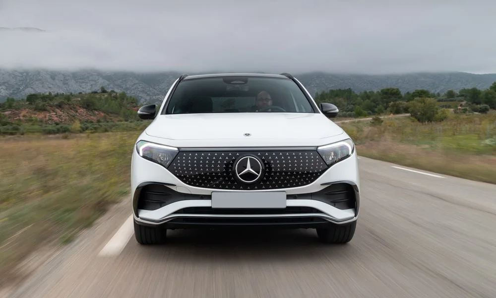 Фото Mercedes-Benz EQA (2024) — вид спереди, фото 6. Белый кузов, строгая симметрия оптики — базовый ракурс знакомства с дизайном. Дневные ходовые огни включаются автоматически с запуском Mercedes-Benz EQA (2024) — вид спереди, фото 6