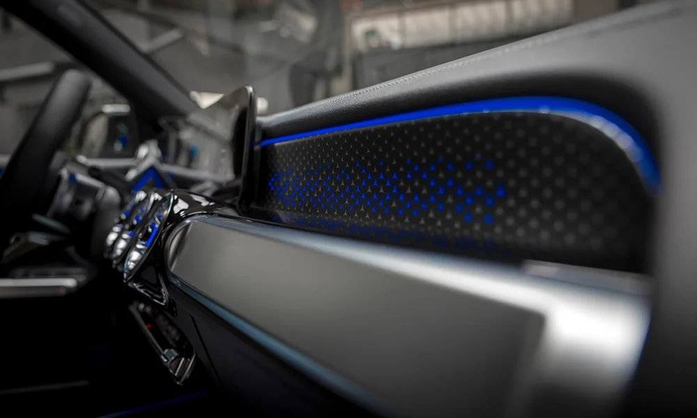 Фото Mercedes-Benz EQB (2024) — дверная карта, фото 2. Внутренняя панель двери: сочетание материалов и компоновка управления в тёмно-синей гамме. Решётка динамика в двери — часть штатной акустики Mercedes-Benz EQB (2024) — дверная карта, фото 2