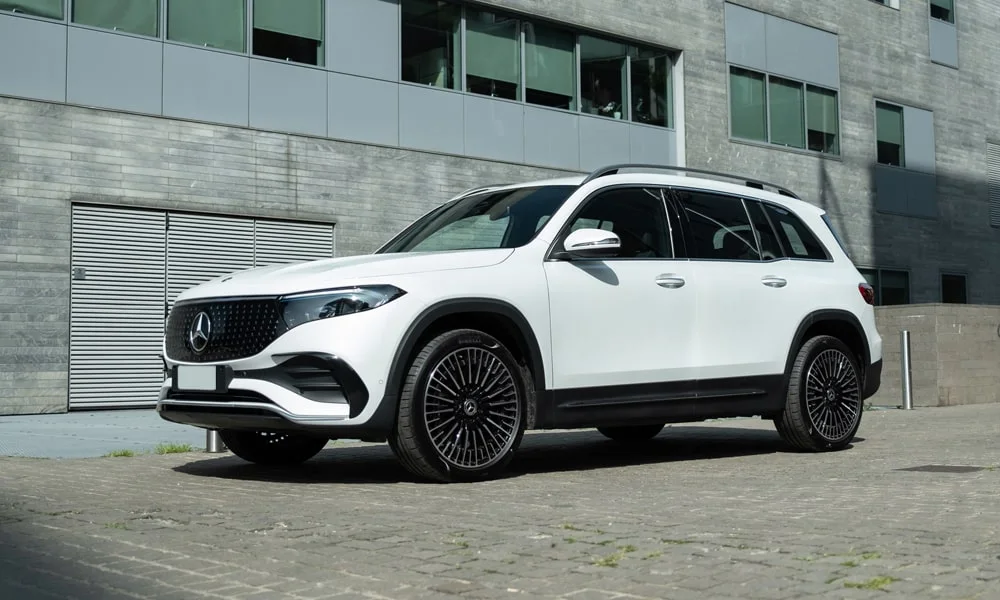 Фото Mercedes-Benz EQB (2024) — вид спереди, фото 3. Белый кузов, строгая симметрия оптики — базовый ракурс знакомства с дизайном. Дневные ходовые огни включаются автоматически с запуском Mercedes-Benz EQB (2024) — вид спереди, фото 3
