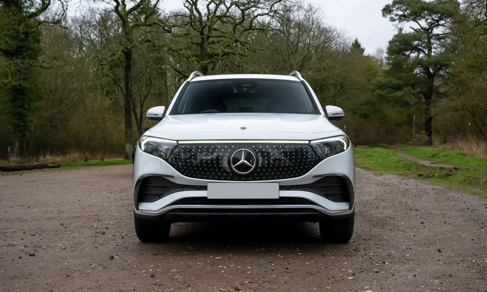 Фото Mercedes-Benz EQB (2024) — вид спереди, фото 9. Кузов в белом цвете: рисунок оптики и решётки задаёт узнаваемое «лицо» модели Mercedes-Benz EQB (2024) — вид спереди, фото 9