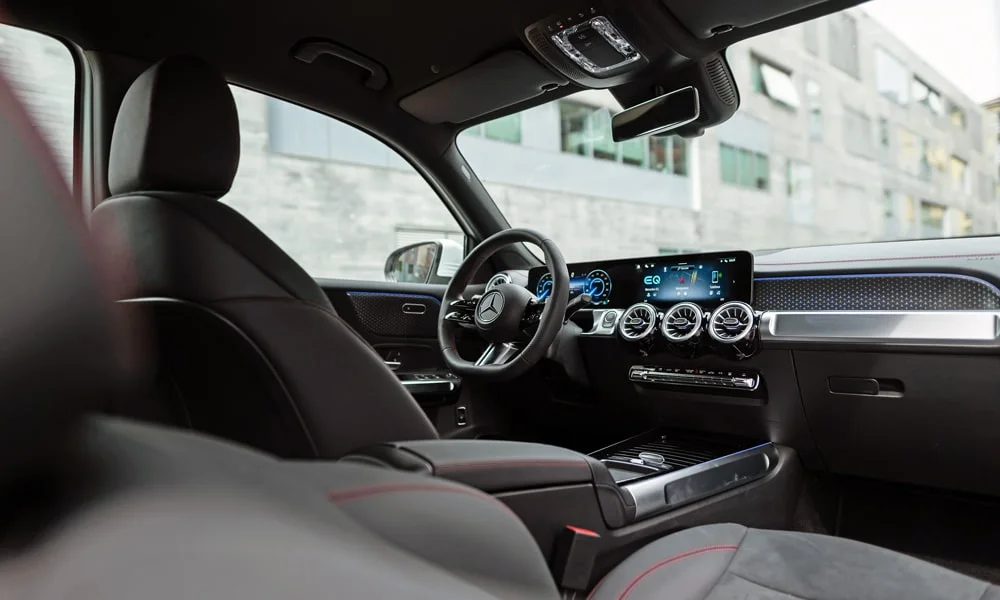 Фото Mercedes-Benz EQB (2024) — интерьер. Общий план салона: архитектура панели, консоль и кресла. Светлая гамма зрительно расширяет салон, тёмная — практичнее в уходе Mercedes-Benz EQB (2024) — интерьер