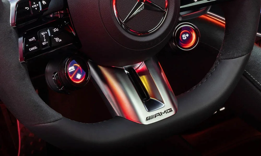 Фото Mercedes-Benz EQE (2024) — руль. Обшивка обода и компоновка спиц крупным планом. Правильная посадка: руки на «9 и 3», приборы читаются поверх обода Mercedes-Benz EQE (2024) — руль