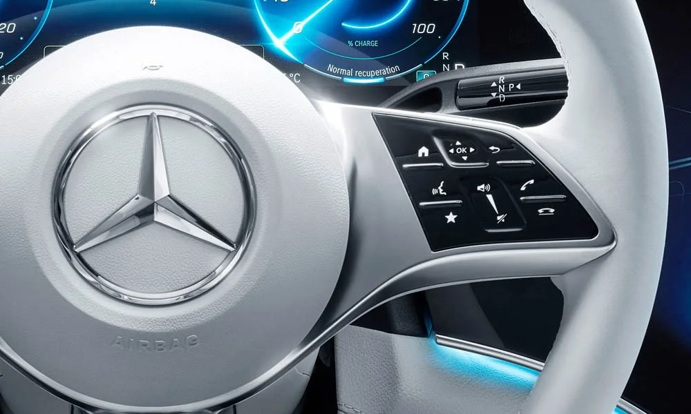 Фото Mercedes-Benz EQE (2024) — руль, фото 2. Обшивка обода и компоновка спиц крупным планом. Клавиши на спицах управляют медиа, круизом и ассистентами — руки остаются на руле Mercedes-Benz EQE (2024) — руль, фото 2