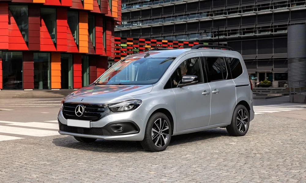 Фото Mercedes-Benz EQT (2024) — вид спереди. Передок в серебристом исполнении — крупная светотехника и выразительный бампер Mercedes-Benz EQT (2024) — вид спереди