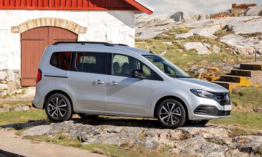 Фото Mercedes-Benz EQT (2024) — вид спереди, фото 2. Кузов в серебристом цвете: рисунок оптики и решётки задаёт узнаваемое «лицо» модели. Рисунок ходовых огней — подпись модели, по нему её узнают в потоке Mercedes-Benz EQT (2024) — вид спереди, фото 2