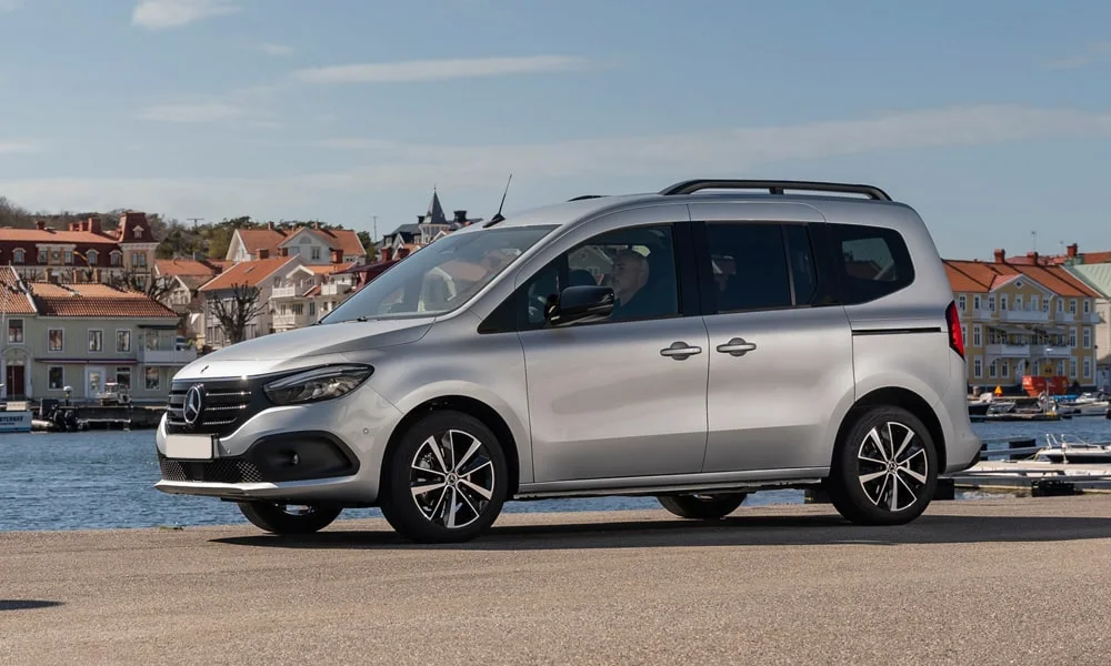 Фото Mercedes-Benz EQT (2024) — вид спереди, фото 8. Серебристый кузов, строгая симметрия оптики — базовый ракурс знакомства с дизайном. Дневные ходовые огни включаются автоматически с запуском Mercedes-Benz EQT (2024) — вид спереди, фото 8