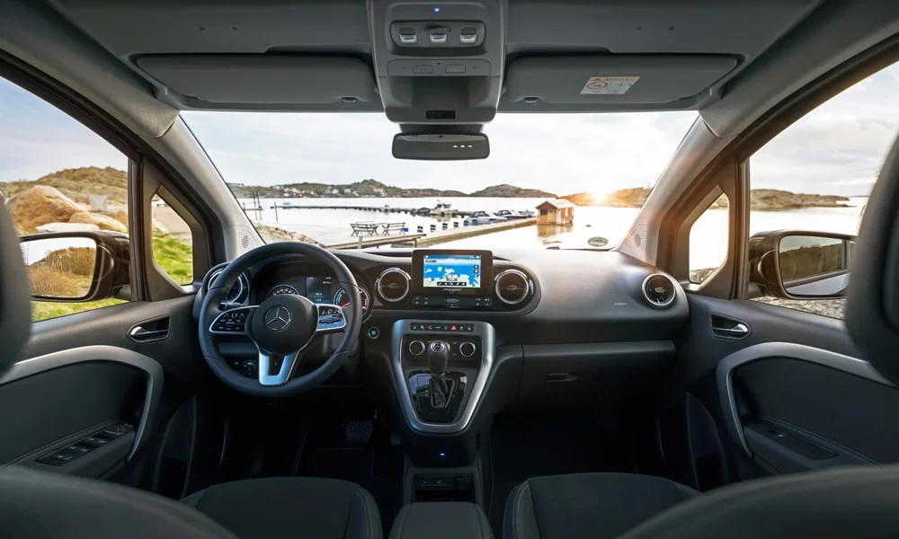 Фото Mercedes-Benz EQT (2024) — интерьер, фото 2. Салон в тёмной отделке: архитектура передней панели, консоль и кресла. Светлая гамма зрительно расширяет салон, тёмная — практичнее в уходе Mercedes-Benz EQT (2024) — интерьер, фото 2