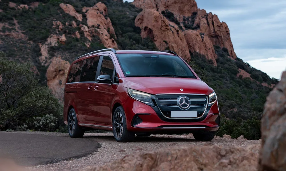 Фото Mercedes-Benz EQV (2024) — вид спереди, фото 10. Передок в красном исполнении — крупная светотехника и выразительный бампер. Дневные ходовые огни включаются автоматически с запуском Mercedes-Benz EQV (2024) — вид спереди, фото 10