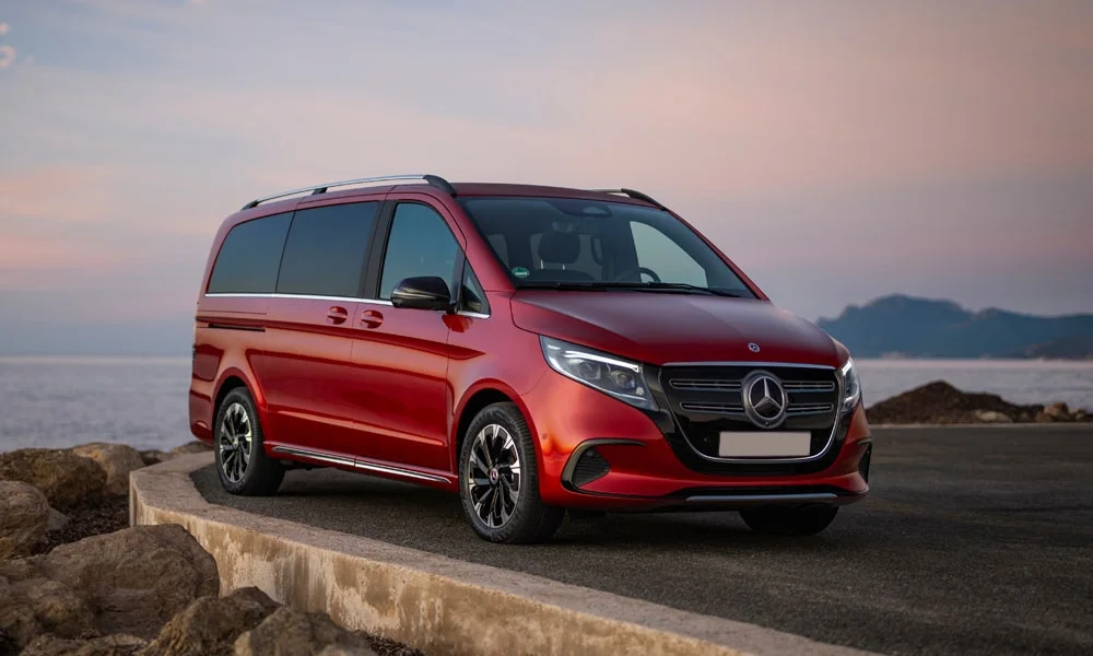 Фото Mercedes-Benz EQV (2024) — вид спереди, фото 11. Красный кузов, строгая симметрия оптики — базовый ракурс знакомства с дизайном Mercedes-Benz EQV (2024) — вид спереди, фото 11