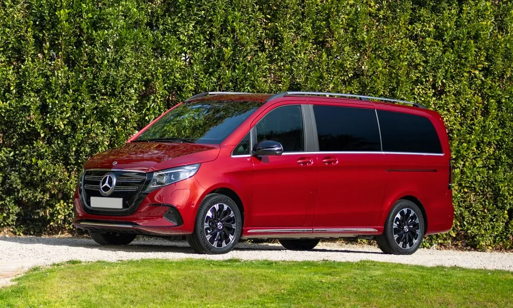 Фото Mercedes-Benz EQV (2024) — вид спереди, фото 12. Передок в красном исполнении — крупная светотехника и выразительный бампер Mercedes-Benz EQV (2024) — вид спереди, фото 12