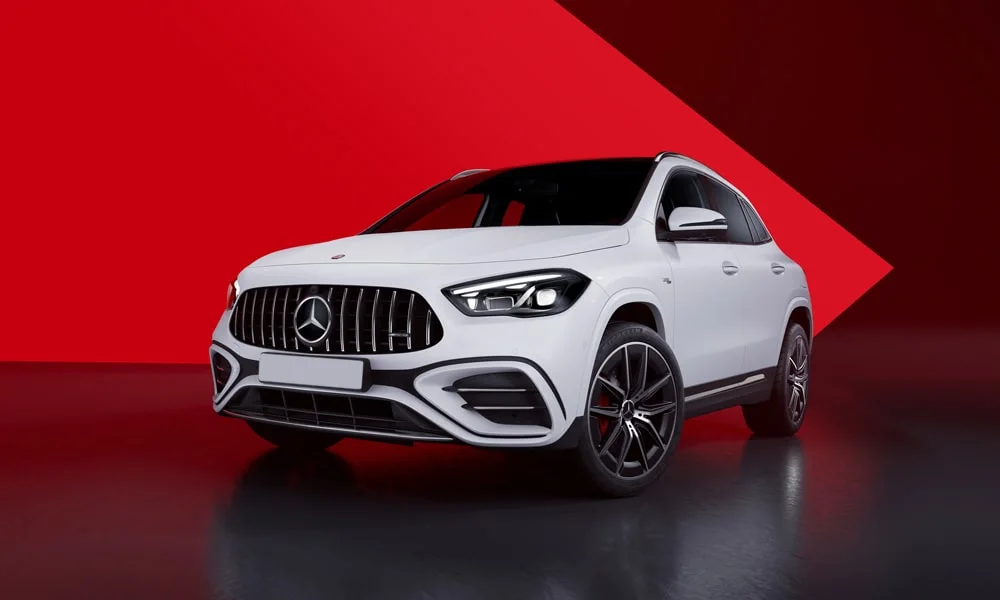Фото Mercedes-Benz GLA (2024) — вид спереди. Передок в белом исполнении — крупная светотехника и выразительный бампер. Рисунок ходовых огней — подпись модели, по нему её узнают в потоке Mercedes-Benz GLA (2024) — вид спереди