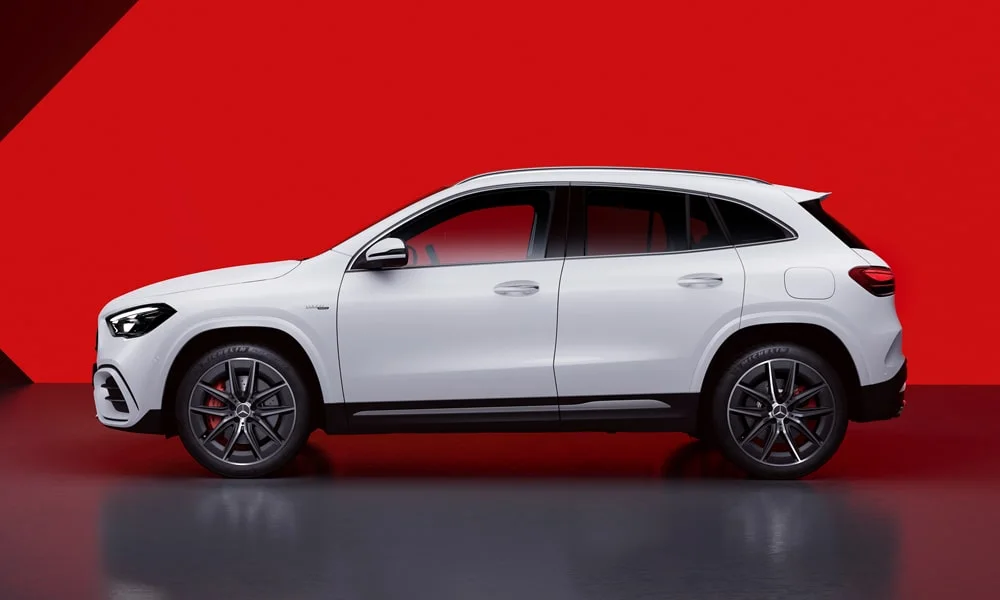 Фото Mercedes-Benz GLA (2024) — вид сбоку. Сбоку читаются линия остекления и характер выштамповок на белом кузове. Хромированные или чёрные молдинги окон отличают комплектации Mercedes-Benz GLA (2024) — вид сбоку